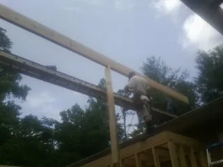 Carpenter setting a ridge beam over a new addition frame — Ice Dam Removal by Roofing Brothers in Womelsdorf