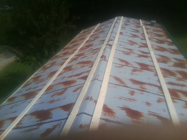 Rusted metal roof panels with new wood purlins before replacement — Storm Damage Roof Repair in Womelsdorf by Roofing Brothers
