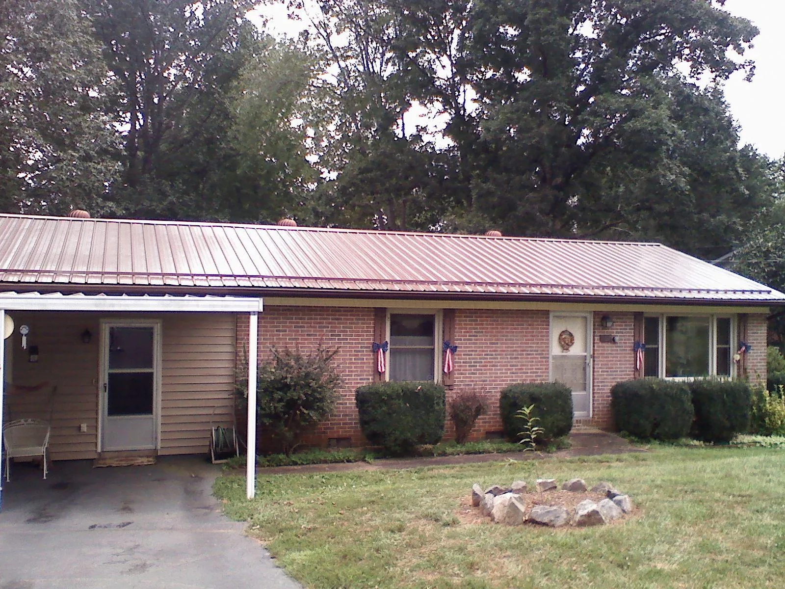 Bronze metal roof and carport on a brick ranch home — Roof Repair work by our crew in Womelsdorf